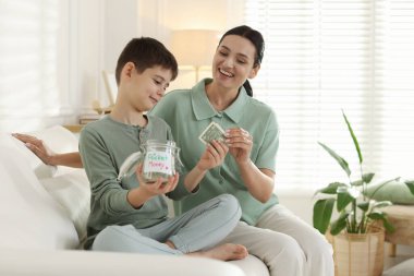 Annem evdeki kanepede oğluna harçlık veriyor.