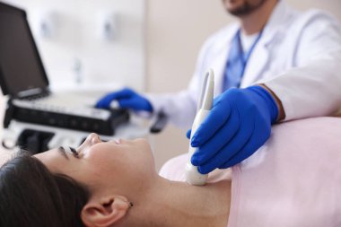 Sonograf klinikte kadının tiroid bezini ultrason taraması yapıyor.