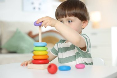 Masada oyuncak piramidiyle oynayan sevimli küçük çocuk.