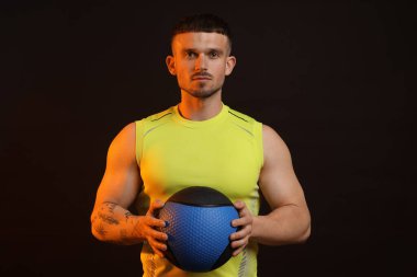 Siyah arka planda tıp topu olan adam.