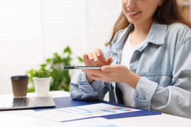 Ofisteki masada akıllı telefondan tarama uygulaması kullanarak belgenin fotoğrafını çeken bir kadın. Metin için boşluk