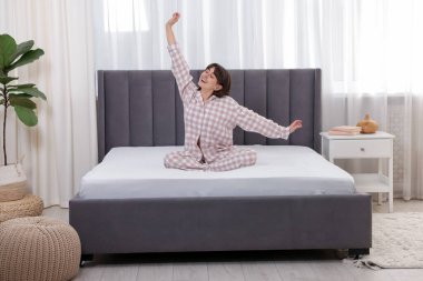 Gülümseyen kadın evde yatakta uzanan