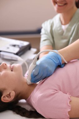 Sonograf, klinikte kızın tiroid bezi ultrason muayenesini yönetiyor.