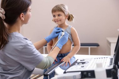 Sonograf klinikte küçük kızın kalbinin ultrason muayenesi yapıyor.