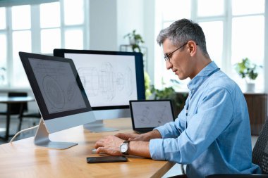 Ofisteki masada bilgisayarla çalışan mühendis.