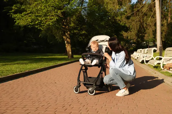 Parktaki bebek arabasında tatlı bebeğiyle annesi. Metin için boşluk