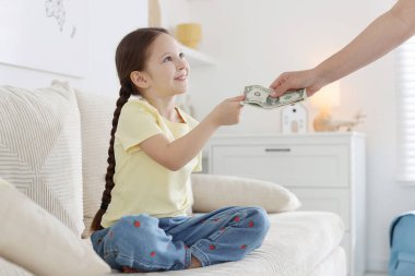 Anne, kızının cep harçlığını evdeki kanepeye veriyor.