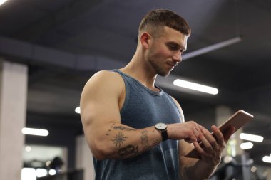 Spor merkezinde tableti olan kişisel antrenör.