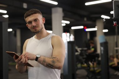 Spor merkezinde tableti olan kişisel antrenör. Metin için boşluk