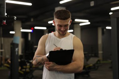 Spor merkezinde panosu olan kişisel antrenör.