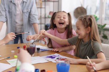 Evde resim dersinde öğretmenleri olan çocuklar. Çizim yapmayı öğrenmek