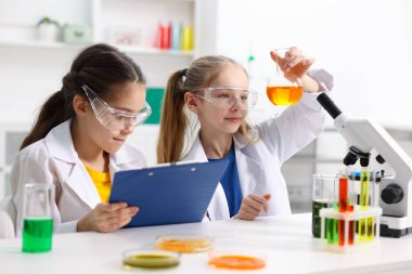 Çocuklar içeride masada kimyasal deneyler yapıyorlar.