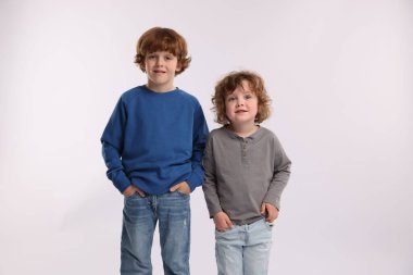 Beyaz arka planda poz veren şirin küçük kardeşler.