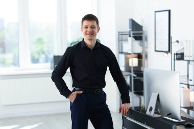 Ofisteki masanın yanındaki yakışıklı adamın portresi.