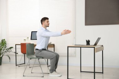 Ofiste sandalyeye uzanan yakışıklı adam.