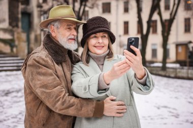 Kış günü selfie çeken sevimli yaşlı çift.