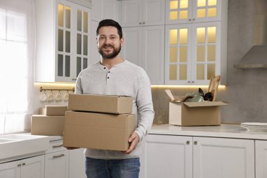 Taşınma günü. Yeni evinde karton kutuları olan bir adam.