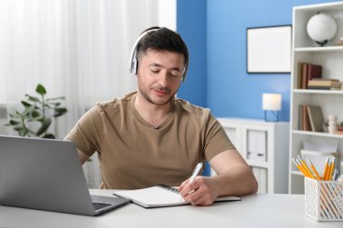 İçerideki masada ders sırasında not alan bir adam. Kendi kendine çalışma.