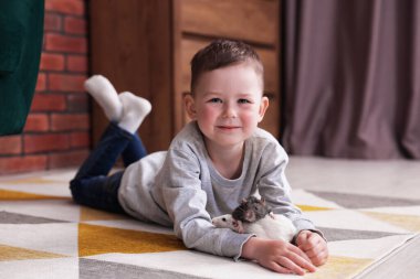 Evinde yerde fareleri olan küçük bir çocuk.