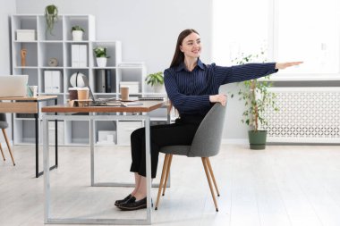 Ofiste sandalyede uzanan güzel bir kadın.