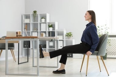 Sandalyede egzersiz yapan güzel bir kadın.