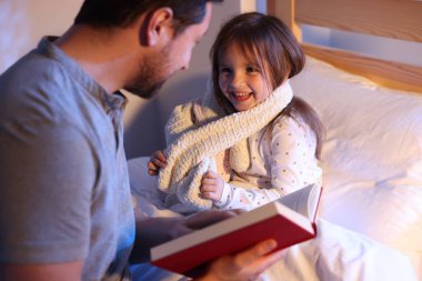 Babası evde mutlu kızına masal okuyor, seçici bir şekilde.