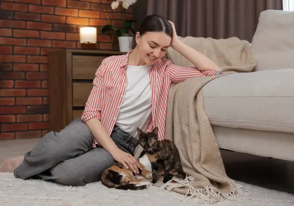 Şirin yavru kedileri evde yerde yatan bir kadın.