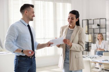 Para bonusu. Patron ofisteki çalışana zarf veriyor.