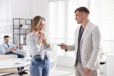 Para bonusu. Patron ofisteki çalışana zarf veriyor.