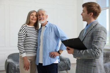 Evinde mutlu bir çift ve panosu olan bir emlakçı.