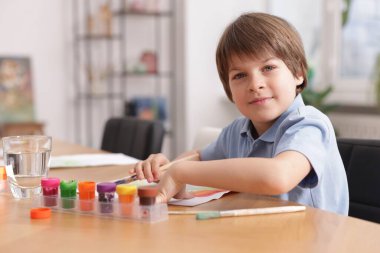 Masada resim yapan sevimli bir çocuk, mesaj için yer var. Çizim yapmayı öğrenmek