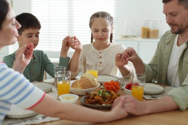 Aile akşam yemeğinden önce evde dua ediyor.