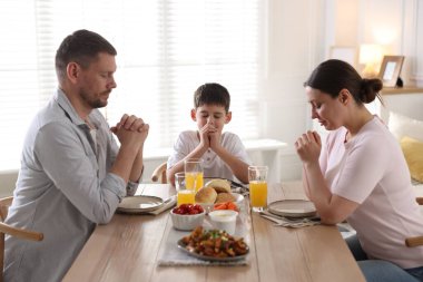 Aile akşam yemeğinden önce evde dua ediyor.