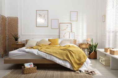 Şık bir odada yumuşak çarşafları olan rahat bir yatak. Ev tekstili