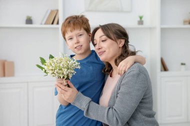 Çocuk, annesine vadideki güzel çiçekleri veriyor.