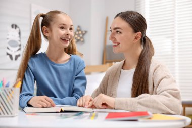 Disleksi. Anne ve kızı evde kitap okuyorlar.