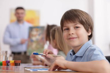 Evde resim dersinde öğretmenleri olan çocuklar, seçici bir odak noktası. Çizim yapmayı öğrenmek