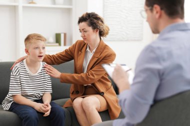 Anne ve oğlu ofiste psikologla görüşüyorlar, seçici odaklanma.