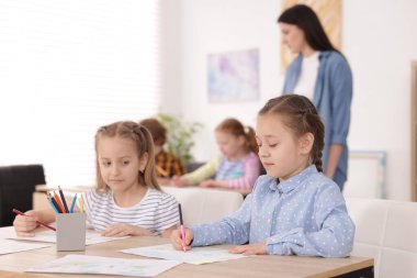 Evde resim dersinde öğretmenleri olan çocuklar, seçici bir odak noktası. Çizim yapmayı öğrenmek