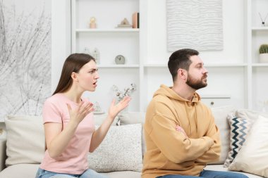 Kızgın çift evdeki kanepede tartışıyor.