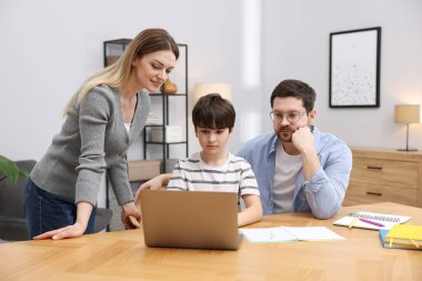 Aileler, oğullarına ev ödevlerinde yardım ediyor.