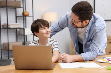 Baba, oğluna ev ödevlerinde yardım ediyor.