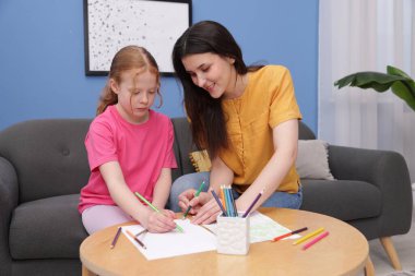 Anne kızına evde çizim yapmayı öğretiyor.