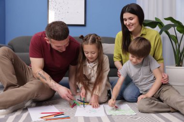 Ebeveynler çocuklarına evde yerde çizim yapmayı öğretiyor.