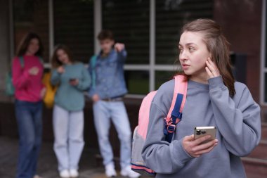 Akıllı telefonlu genç bir kız okulda zorbalıktan muzdarip, seçici bir odak noktası var.