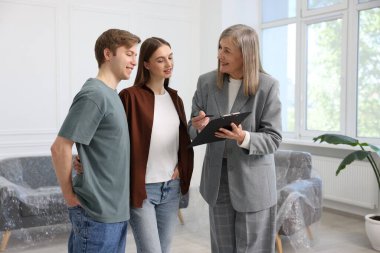 Gülümseyen emlakçı evde çiftlerle çalışıyor.