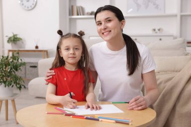 Anne kızına evde çizim yapmayı öğretiyor.