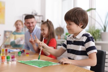 Resim dersinde öğretmenleri olan çocuklar, seçici odaklanma. Çizim yapmayı öğrenmek