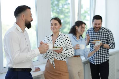 Yemek ve içeceklerle iş arkadaşları öğle arasında ofiste pencere kenarında.
