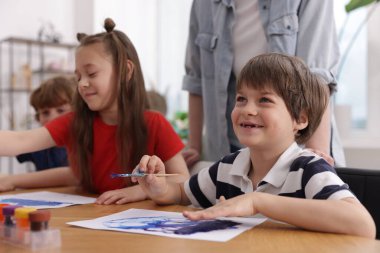 Resim dersinde öğretmenleri olan çocuklar. Çizim yapmayı öğrenmek